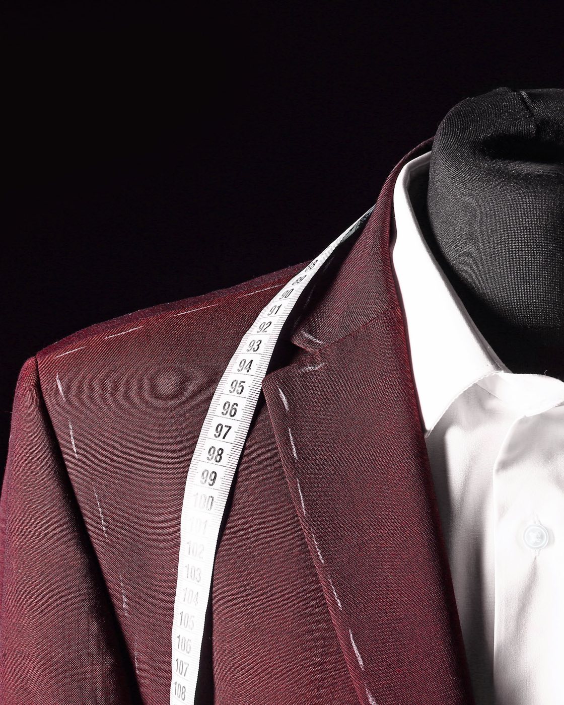 A tailored jacket on a dressform, with a tape measure